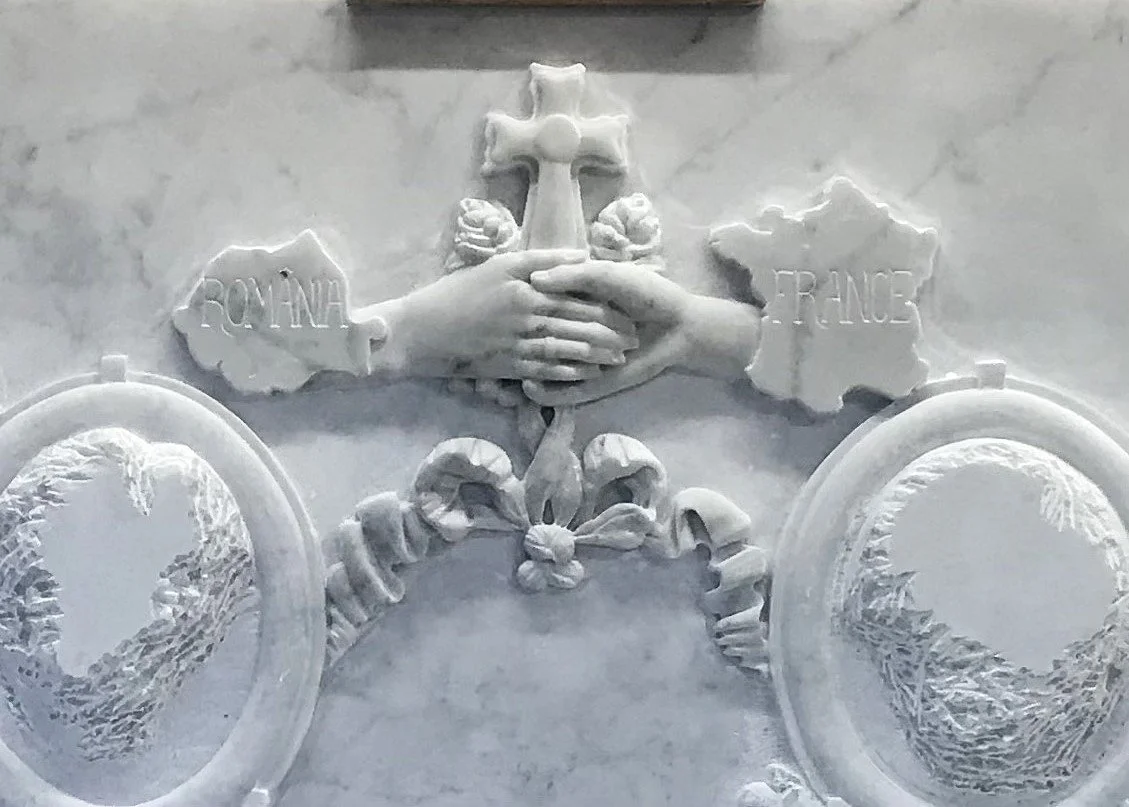 Mains sculptées autour de la croix sur le monument familial